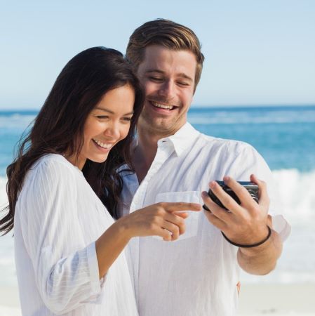 Paar mit Smartphone am Strand