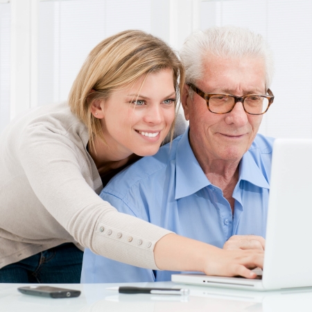 Frau mit alten Mann am Laptop