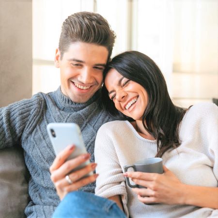 Junges Paar auf Sofa mit Smartphone