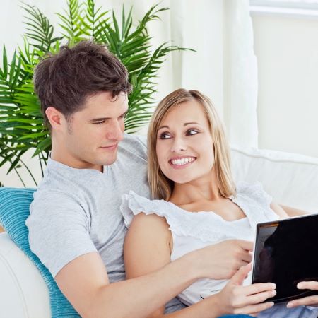 Junges Paar auf Sofa mit Tablet