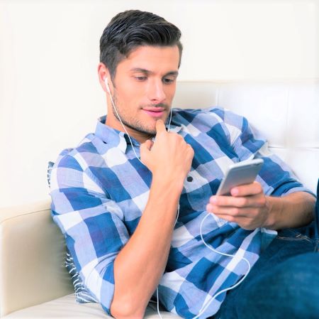 Mann mit Smartphone auf Sofa